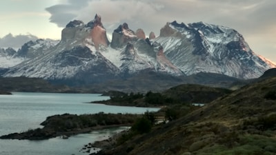 A breathtaking 4k shot of snow-capped peaks reflected perfectly in an icy glacial lake at dawn.