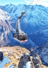 bird's eye view of ski lift over mountains during winter