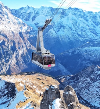 bird's eye view of ski lift over mountains during winter