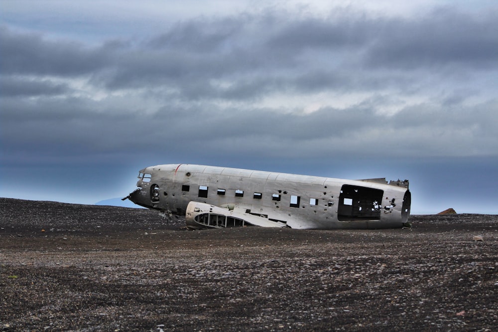 crushed plane on soil under gray sky during daytime