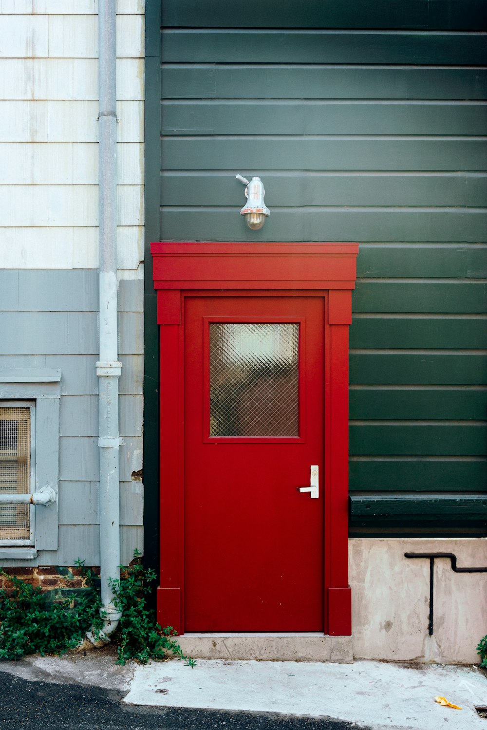 Puerta pintada de rojo con pared verde