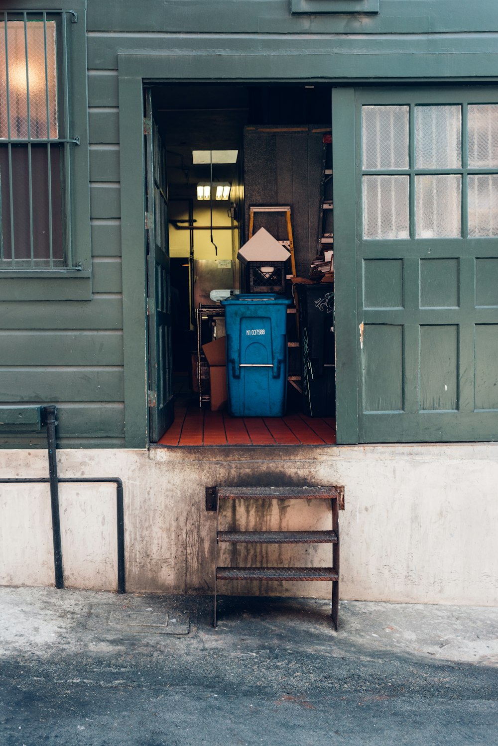 a wooden bench sitting in front of a green building