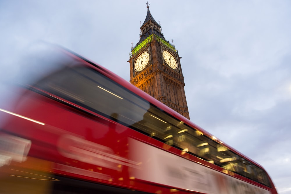 fotografía panorámica de un autobús de dos pisos que pasa por Elizabeth Tower