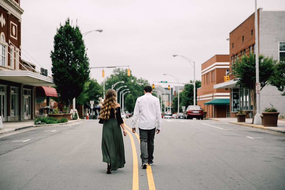 man and woman walking in the middle of the road