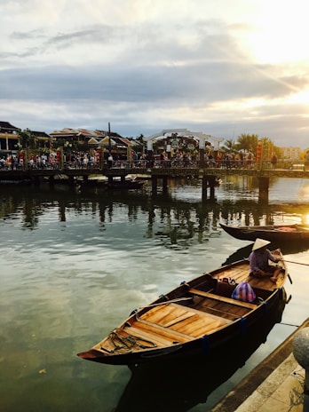 A peaceful scene of a traditional Vietnamese boat floating on a calm river at sunset.