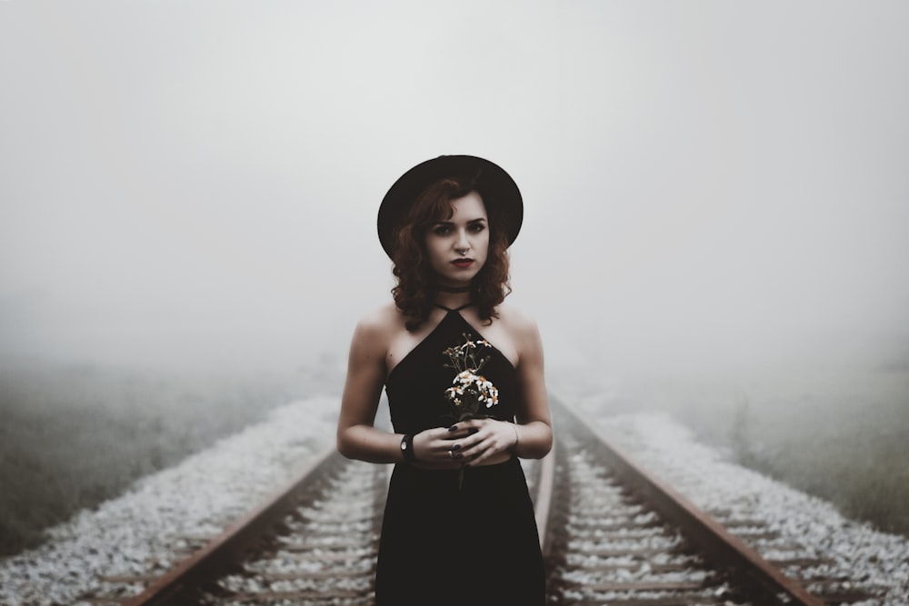 woman holding her hands on railroad