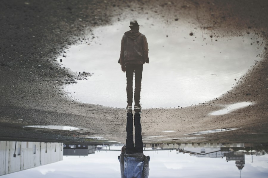 A man's reflection on still water, representing a shadow run that mirrors production without ever being seen