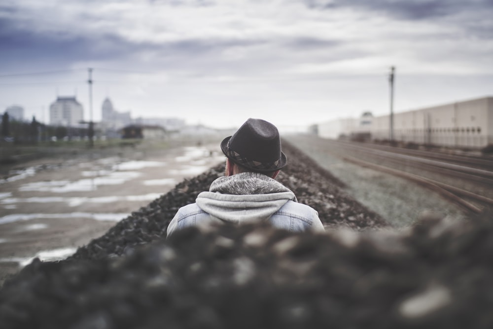 selective focus of man sitting beside body of water