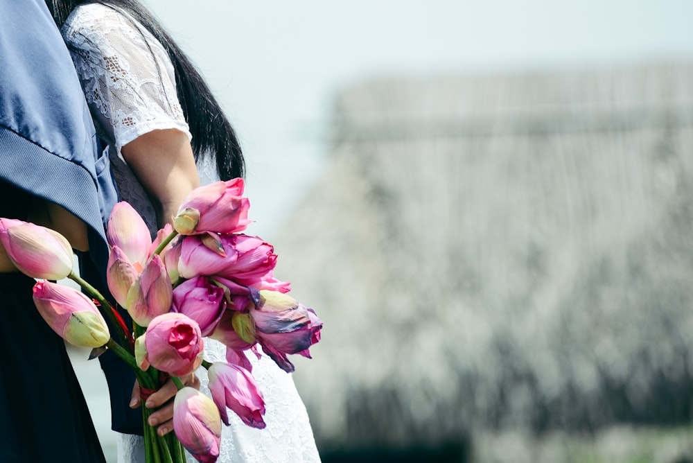 woman holding pink flowers