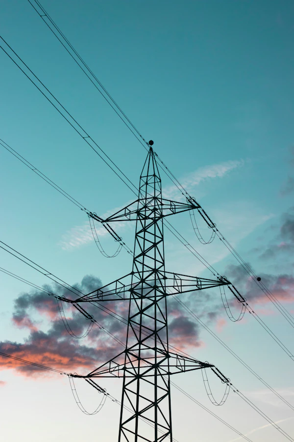 A black electricity transmission tower against the sky