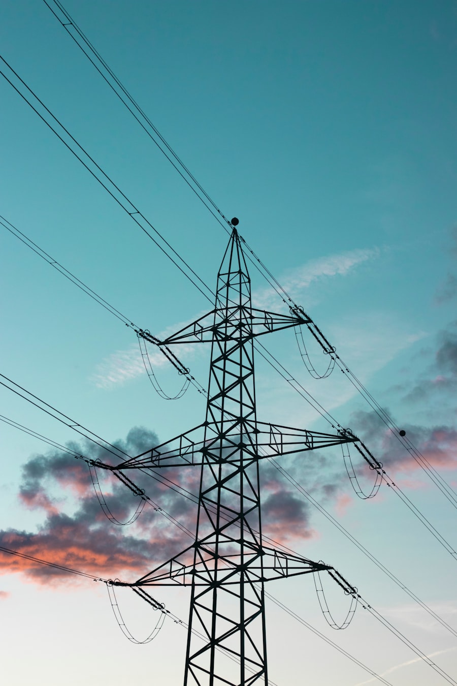 Transmission pylon silhouette against teal sky