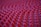 A close-up view of a surface covered with numerous small, rounded, red protrusions arranged in a grid pattern.