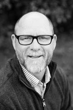 grayscale of man wearing eyeglasses