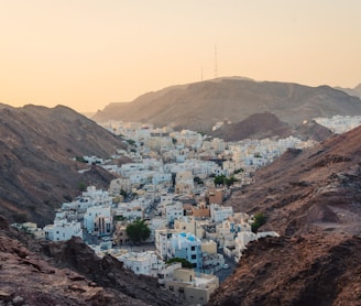 aerial view of white concrete buildings near rock cliffs