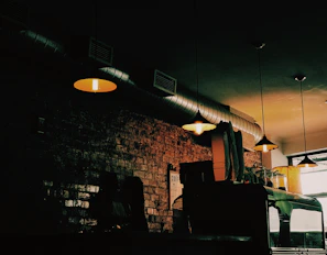 Industrial-style concrete and metal coffee bar with soft ambient lighting.