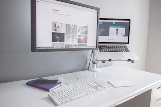 A clean, minimalist workspace with a laptop displaying financial spreadsheets.