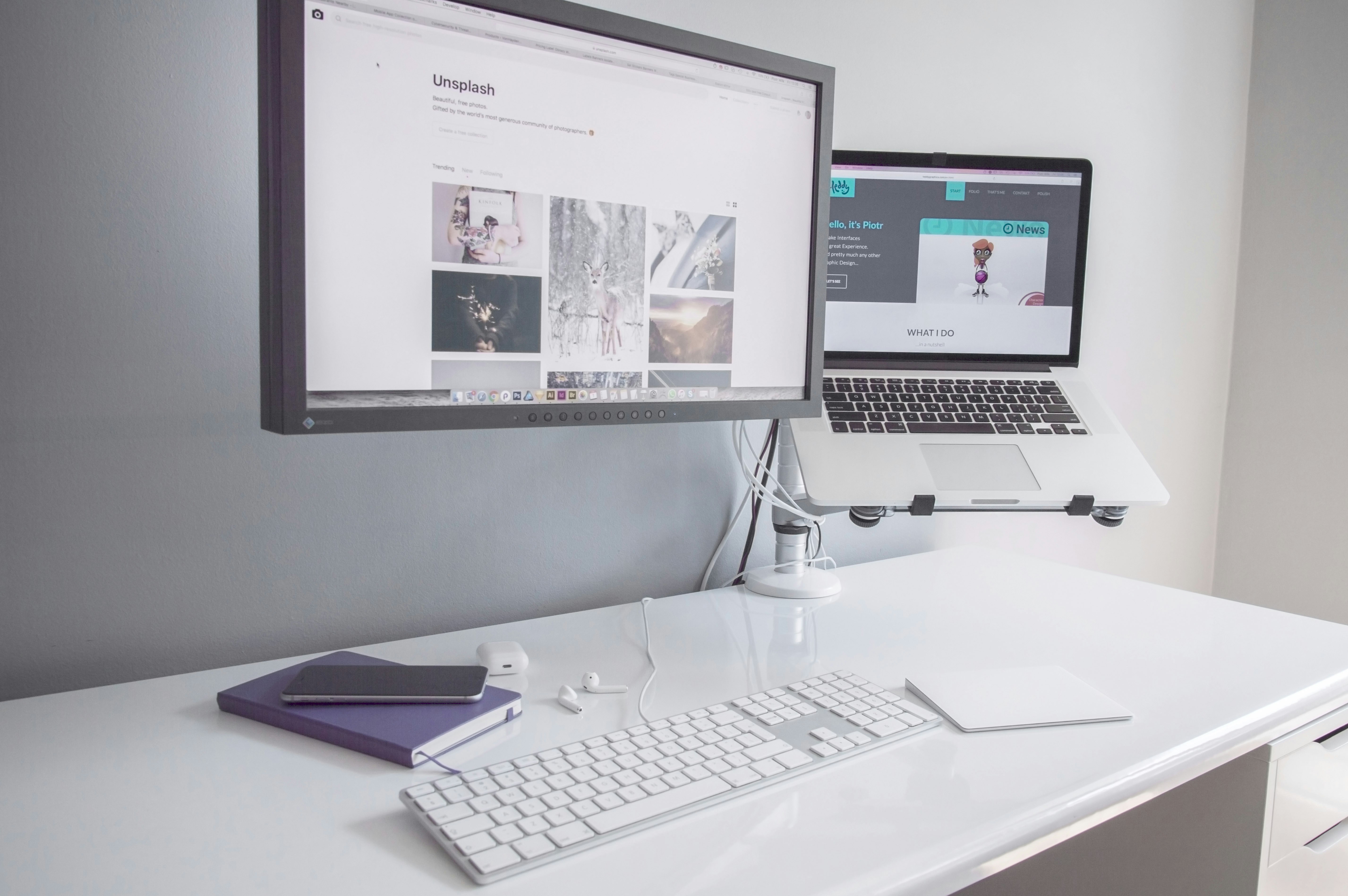 clean modern office desk with dual monitors displaying code