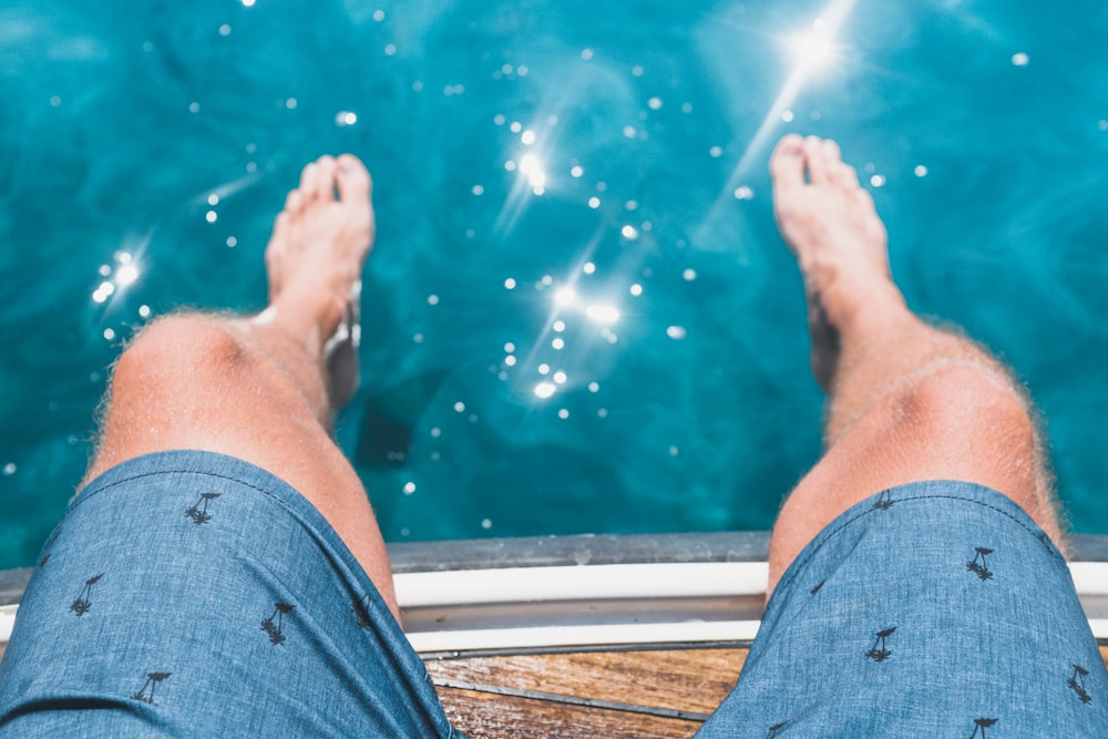 fotografia aérea dos pés de uma pessoa na água
