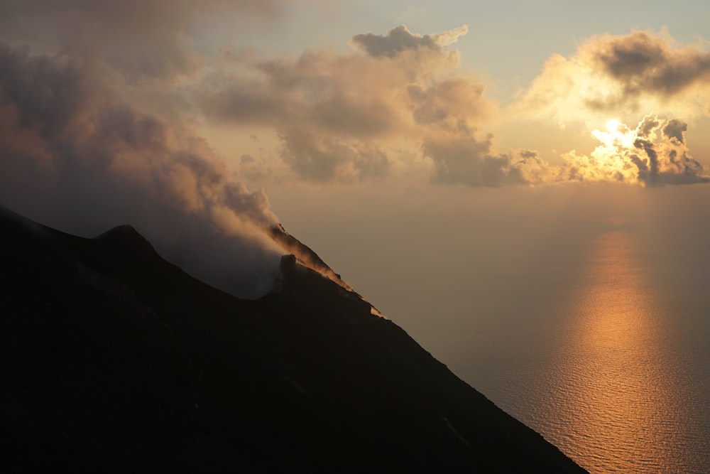 mountain near ocean during orange sunset