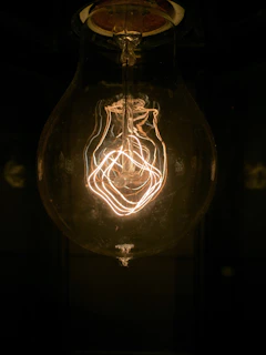 Close-up of a glowing LED bulb illuminating a modern workspace with warm light.