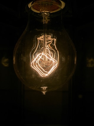Close-up of a sleek LED bulb glowing warmly in a modern living room setting.