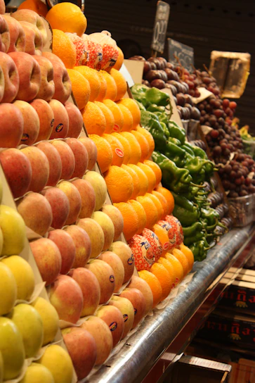 A vibrant display of fresh fruits and vegetables arranged neatly on a market stall.