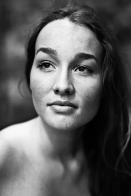 A serene black and white portrait photo capturing natural light on a subject's face.