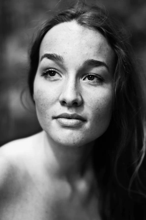 A serene black and white portrait capturing raw emotion in natural light.