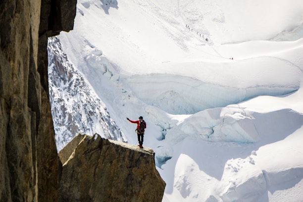 person standing on top of mountain beside snow mountian