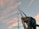 Photo of a happy sailor holding nautical ropes on a boat deck under a clear blue sky