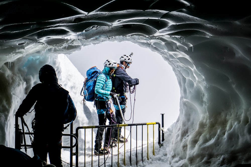 people walking on ice covered cave
