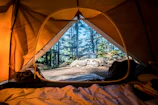 Close-up of a cozy tent interior with soft lighting and camping gear neatly arranged.