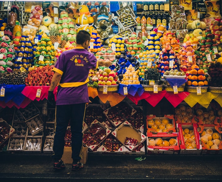 man standing in front of produce stand