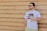 man wearing eyeglasses holding plastic cup standing in front of brown wall