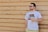 man wearing eyeglasses holding plastic cup standing in front of brown wall