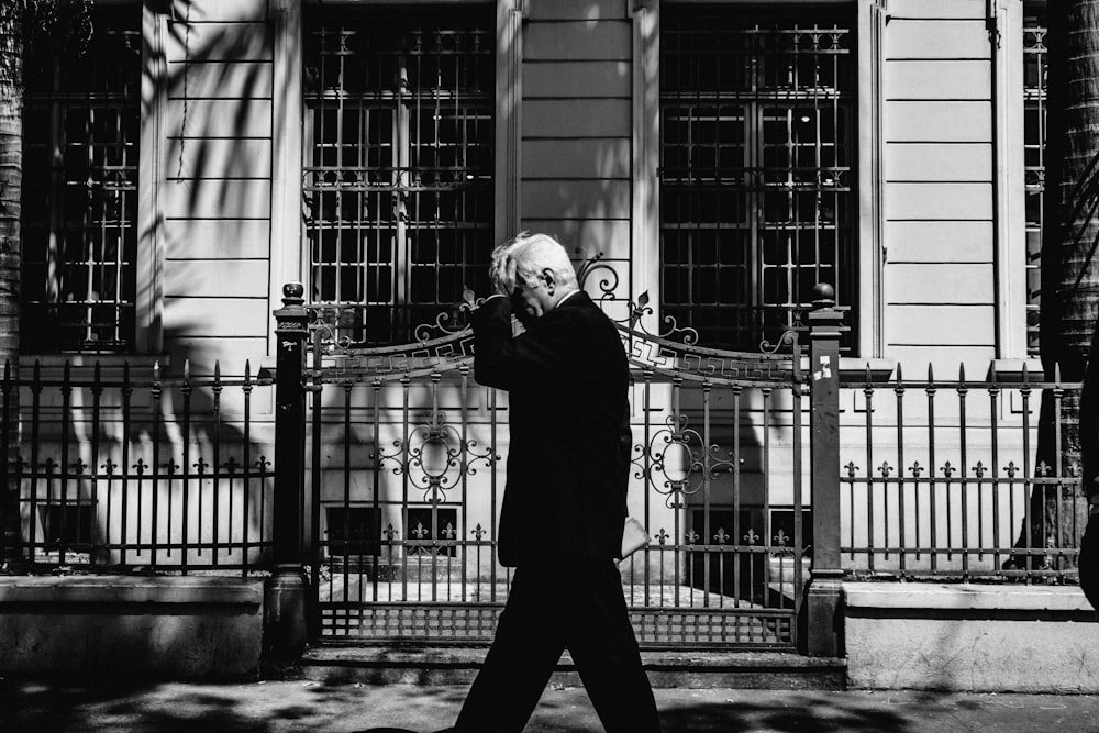 man walking along fence