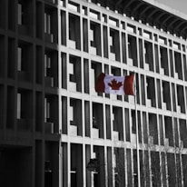 A welcoming Canadian flag waving outside a modern immigration office.
