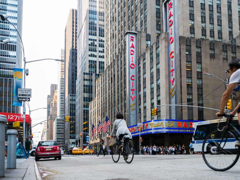 person riding bicycle on street beside building