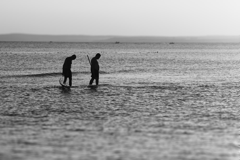 silueta de dos hombres en el cuerpo de agua