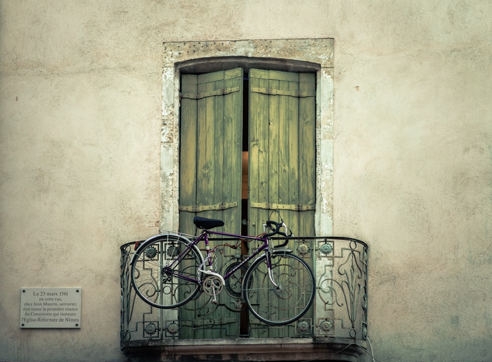 black bike hanged on false balcony