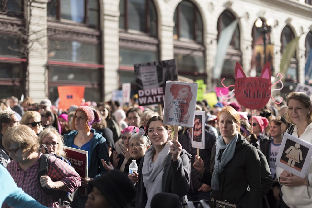 people holding flyers during daytime