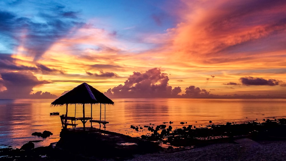 silhouette of cottage on beach