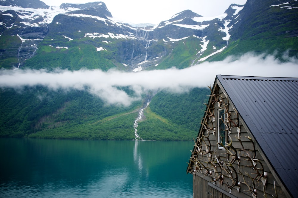 green mountain with waterfalls surrounded by body of water