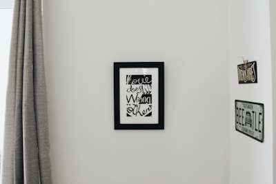 Wide shot of a minimalist gallery wall displaying colorful fileteado artworks.