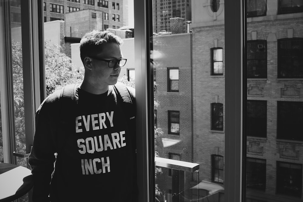 a man standing in front of a window with a sign on it