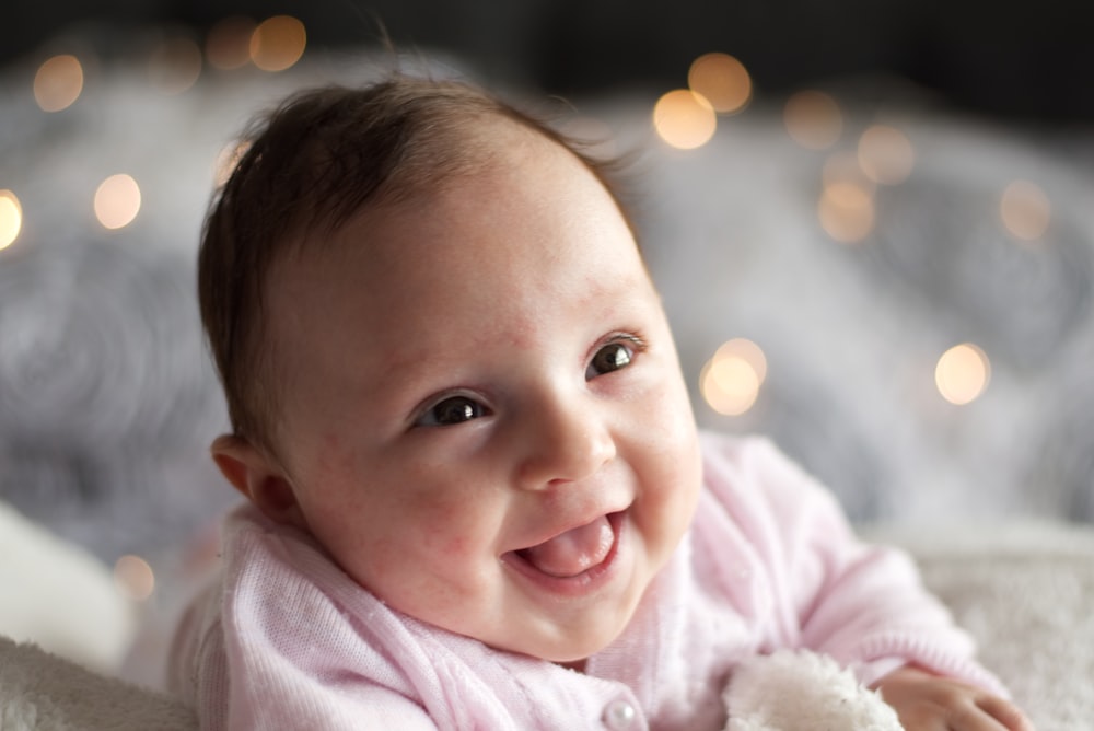 A baby smiling with his mouth open.