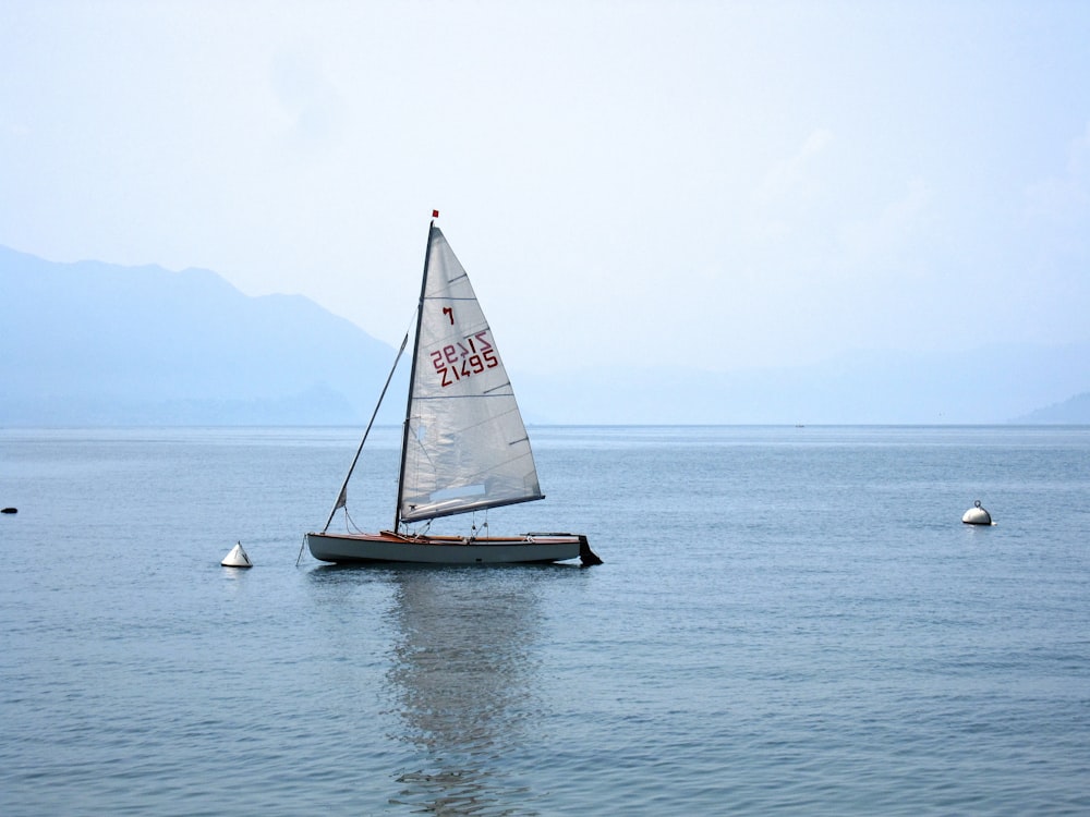 a small sailboat floating on top of a large body of water