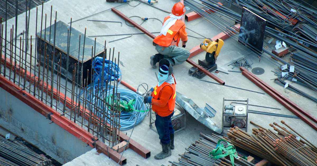 Construction site management team reviewing digital blueprints on tablets
