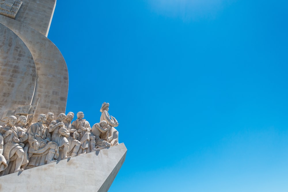 a statue of a group of people in front of a blue sky