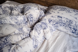 blue and white pillow on white bed